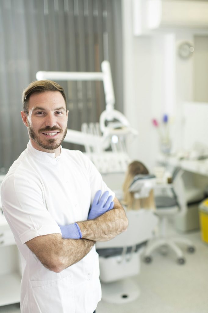 young dentist posing in dental office